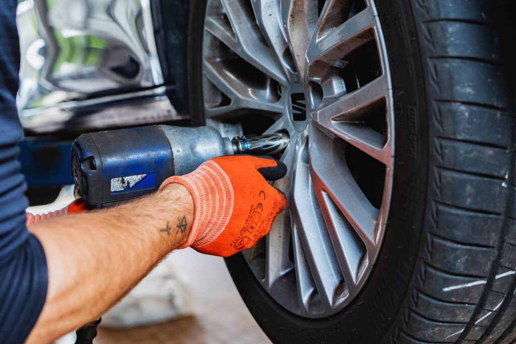 Reifenservice in München. Mitarbeiter beim Reifenwechsel im Autohaus Spratter